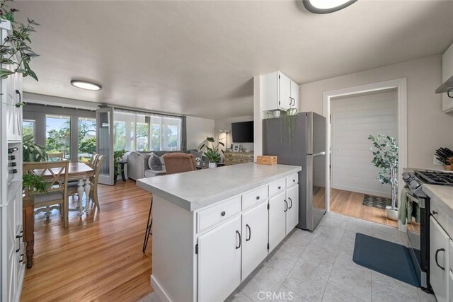 1215 Sylvia Ct, San Luis Obispo, CA 93401 - kitchen with stainless steel appliances, a peninsula, light countertops, and white cabinetry