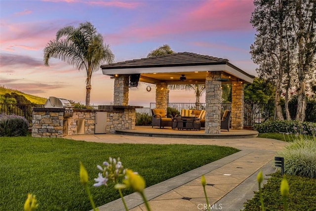 4560 San Antonio Rd, Yorba Linda, CA 92886 - patio terrace at dusk with a gazebo, an outdoor kitchen, an outdoor hangout area, a ceiling fan, and a patio