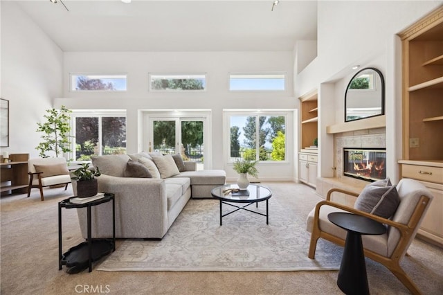 993 Las Palmas Way, San Luis Obispo, CA 93401 - living room featuring carpet floors, a towering ceiling, a tile fireplace, and built in shelves