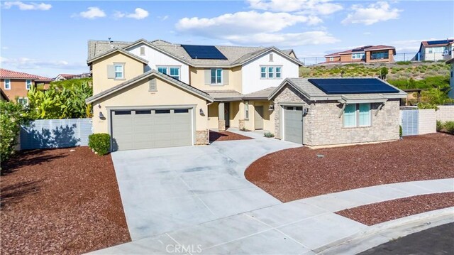 17150 Vita Way, Riverside, CA 92503 - view of front facade featuring roof mounted solar panels, concrete driveway, stone siding, and stucco siding
