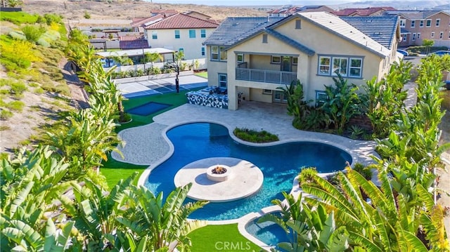17150 Vita Way, Riverside, CA 92503 - back of house featuring stucco siding, a patio area, a balcony, a residential view, and a pool with connected hot tub