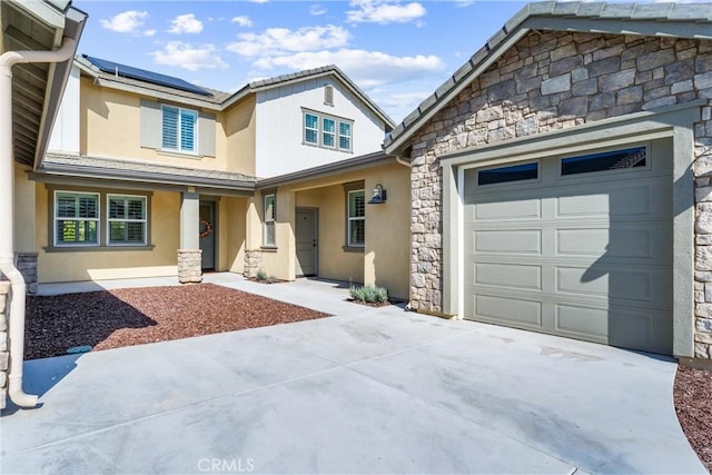 17150 Vita Way, Riverside, CA 92503 - view of front of house featuring stone siding, driveway, roof mounted solar panels, and stucco siding