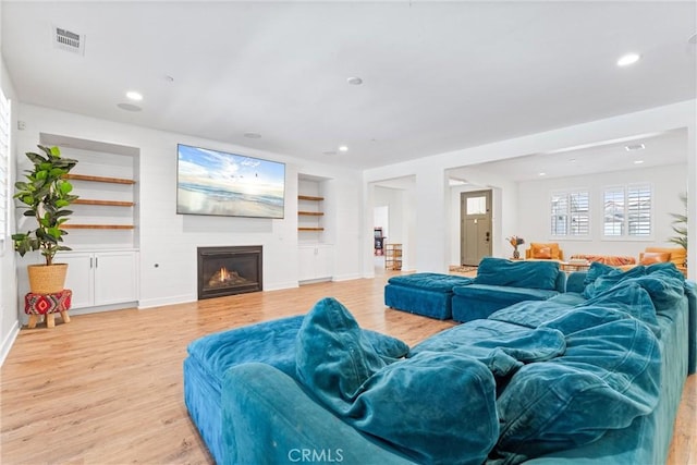 17150 Vita Way, Riverside, CA 92503 - living room with light wood-type flooring, built in features, a warm lit fireplace, recessed lighting, and baseboards