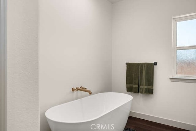 5540 Scottwood Rd, Paradise, CA 95969 - bathroom with a freestanding bath, wood finished floors, and baseboards