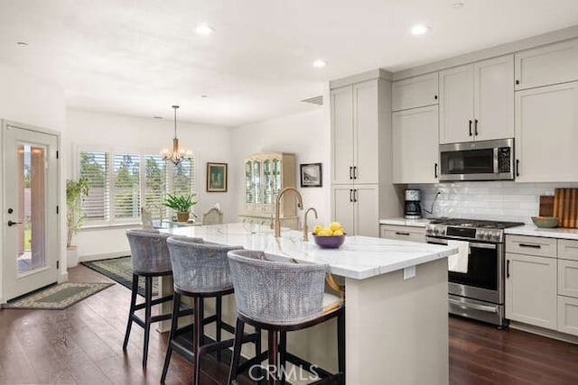 5540 Scottwood Rd, Paradise, CA 95969 - kitchen with appliances with stainless steel finishes, tasteful backsplash, dark wood-style flooring, light stone counters, and recessed lighting