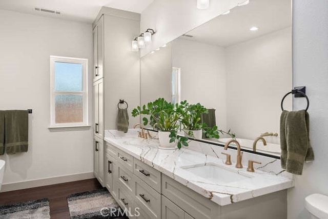 5540 Scottwood Rd, Paradise, CA 95969 - full bath with double vanity, wood finished floors, baseboards, and toilet
