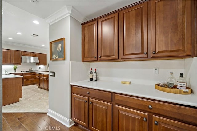 38872 Cherry Point Ln, Murrieta, CA 92563 - kitchen featuring under cabinet range hood, ornamental molding, brown cabinetry, and recessed lighting