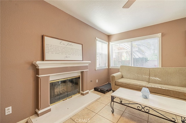 5531 Cordiva Ct, Lancaster, CA 93536 - tiled living area with a ceiling fan, a glass covered fireplace, and a textured wall
