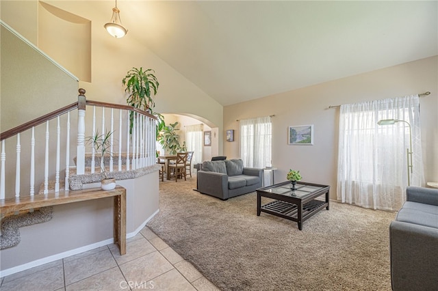 5531 Cordiva Ct, Lancaster, CA 93536 - carpeted living area featuring arched walkways, high vaulted ceiling, stairs, and tile patterned flooring