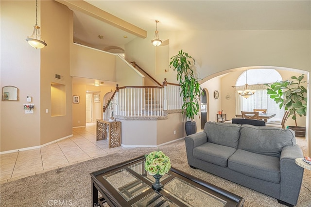 5531 Cordiva Ct, Lancaster, CA 93536 - living area featuring carpet floors, arched walkways, tile patterned flooring, stairway, and baseboards