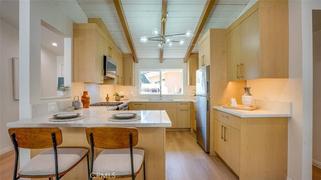 16347 Tupper St, North Hills, CA 91343 - kitchen featuring light brown cabinetry, a peninsula, light wood-type flooring, wooden ceiling with exposed beams, and stainless steel appliances