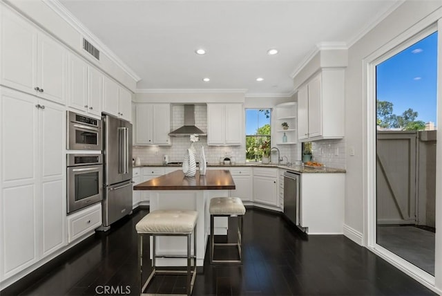 20 Fecamp, Newport Coast, CA 92657 - kitchen featuring wall chimney exhaust hood, stainless steel appliances, dark wood finished floors, white cabinets, and a center island