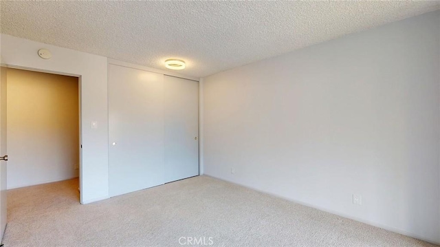 649 Paseo De La Playa Unit 303, Redondo Beach, CA 90277 - unfurnished bedroom with light colored carpet, a closet, and a textured ceiling