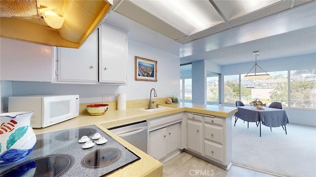 649 Paseo De La Playa Unit 303, Redondo Beach, CA 90277 - kitchen featuring white microwave, a sink, stainless steel dishwasher, light countertops, and a peninsula