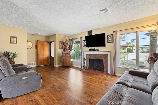 945 W Bonnie Brae Ct, Ontario, CA 91762 - living room featuring a textured ceiling, wood finished floors, healthy amount of natural light, a brick fireplace, and baseboards