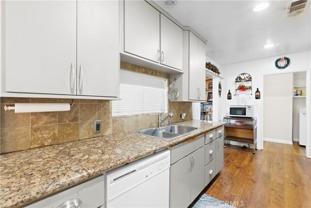 945 W Bonnie Brae Ct, Ontario, CA 91762 - kitchen with white appliances, a sink, decorative backsplash, light wood finished floors, and light stone counters