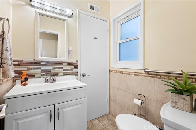 945 W Bonnie Brae Ct, Ontario, CA 91762 - half bath featuring tile walls, toilet, tile patterned flooring, vanity, and wainscoting