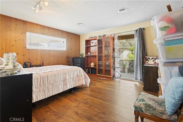 945 W Bonnie Brae Ct, Ontario, CA 91762 - bedroom with wood finished floors, wood walls, a textured ceiling, and track lighting