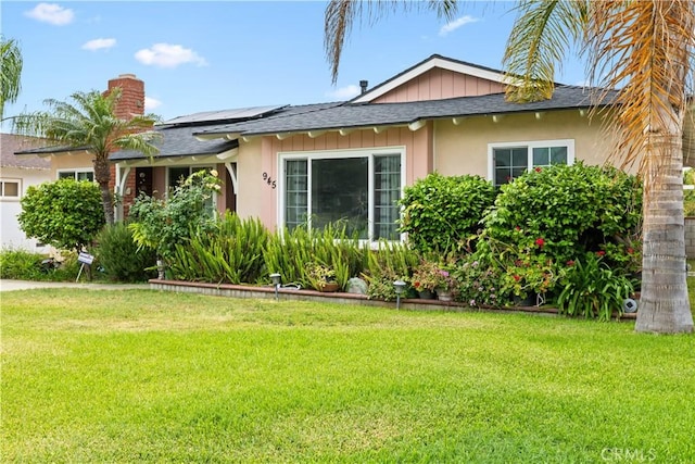 945 W Bonnie Brae Ct, Ontario, CA 91762 - view of front of house with a front lawn, roof mounted solar panels, a chimney, and roof with shingles