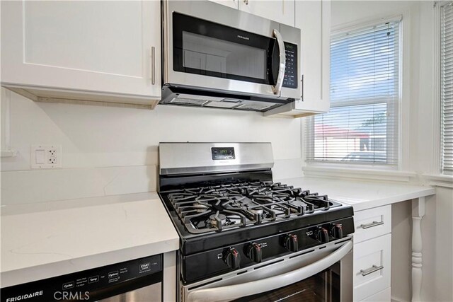 4427 Exposition Blvd, Los Angeles, CA 90016 - kitchen with appliances with stainless steel finishes, white cabinetry, and light stone counters