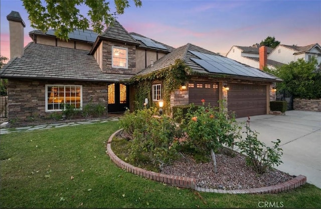 4187 Pepper Ave, Yorba Linda, CA 92886 - view of front of house featuring stone siding, driveway, a front lawn, a garage, and roof mounted solar panels
