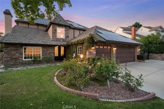 4187 Pepper Ave, Yorba Linda, CA 92886 - view of front of house with stone siding, an attached garage, driveway, a front yard, and roof mounted solar panels