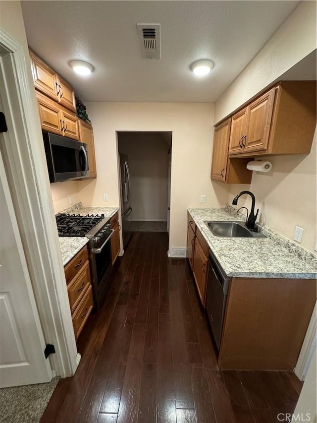 4187 Pepper Ave, Yorba Linda, CA 92886 - kitchen featuring appliances with stainless steel finishes, dark wood-type flooring, light stone counters, and brown cabinets