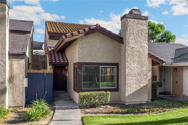 625 E Merion St, Ontario, CA 91761 - entrance to property featuring stucco siding, a tile roof, and a chimney