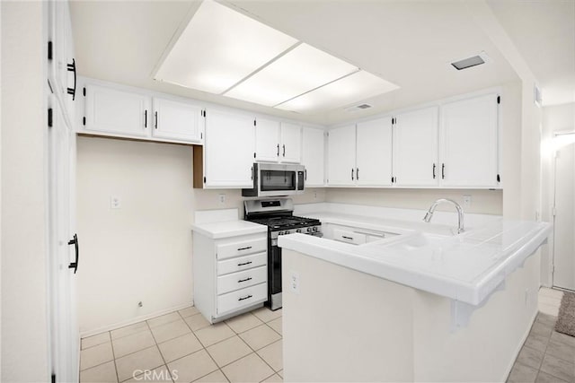625 E Merion St, Ontario, CA 91761 - kitchen featuring appliances with stainless steel finishes, a peninsula, white cabinetry, and light tile patterned floors
