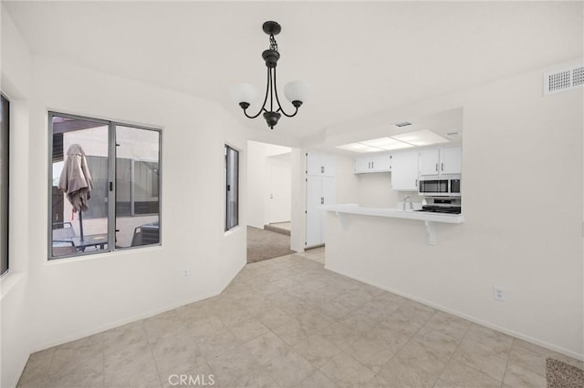625 E Merion St, Ontario, CA 91761 - unfurnished living room featuring baseboards, light flooring, and a chandelier