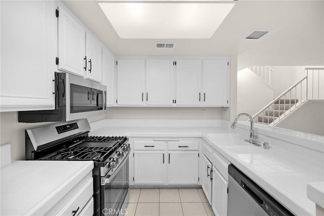 625 E Merion St, Ontario, CA 91761 - kitchen with appliances with stainless steel finishes, tile counters, and white cabinets
