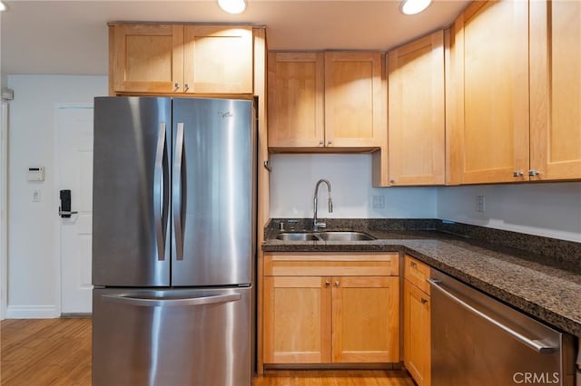 3061 W 12th Pl Unit 101, Los Angeles, CA 90006 - kitchen with stainless steel appliances, a sink, light wood finished floors, dark stone counters, and baseboards