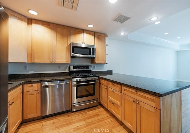 3061 W 12th Pl Unit 101, Los Angeles, CA 90006 - kitchen with stainless steel appliances, a peninsula, light wood-style floors, recessed lighting, and dark stone counters