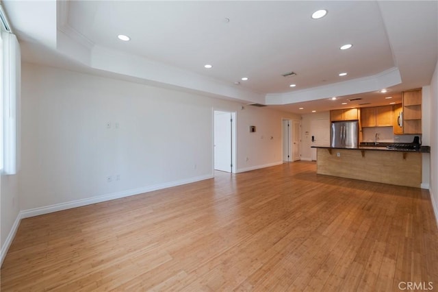 3061 W 12th Pl Unit 101, Los Angeles, CA 90006 - unfurnished living room with a tray ceiling, crown molding, light wood finished floors, baseboards, and recessed lighting