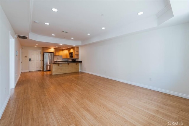 3061 W 12th Pl Unit 101, Los Angeles, CA 90006 - unfurnished living room featuring a raised ceiling, light wood-type flooring, baseboards, and recessed lighting