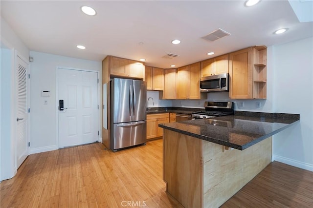 3061 W 12th Pl Unit 101, Los Angeles, CA 90006 - kitchen with appliances with stainless steel finishes, a peninsula, baseboards, open shelves, and light wood-type flooring