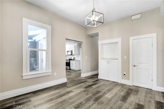 1835 Martin Luther King Blvd, Riverside, CA 92507 - unfurnished dining area with a chandelier, wood finished floors, and baseboards