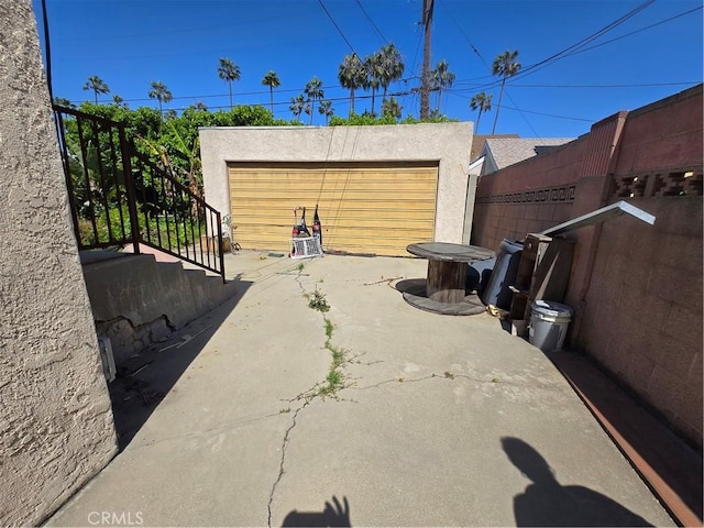 5738 S Mullen Ave, Los Angeles, CA 90043 - view of patio / terrace with stairs, a garage, and an outbuilding