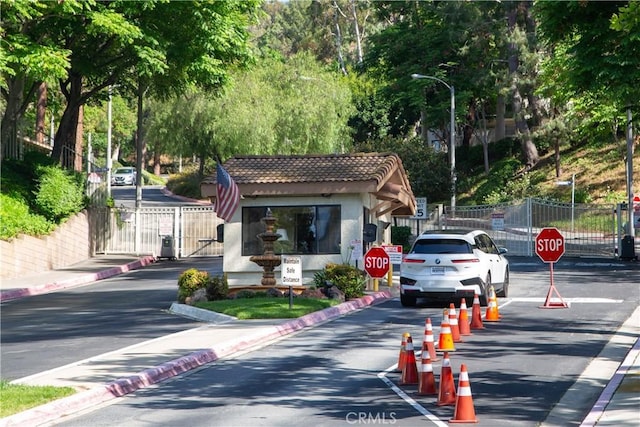 22890 Hilton Head Dr Unit 294, Diamond Bar, CA 91765 - view of asphalt street with traffic signs, a gate, curbs, and street lights