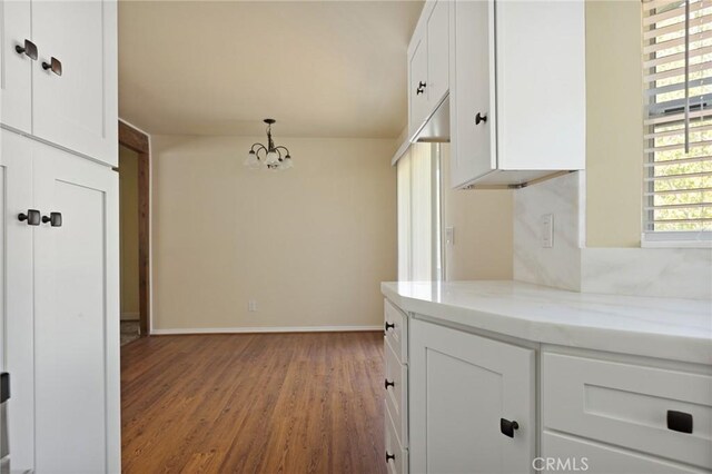 32296 Fern Dr, Running Springs, CA 92382 - kitchen with white cabinetry, a chandelier, wood finished floors, light stone counters, and baseboards