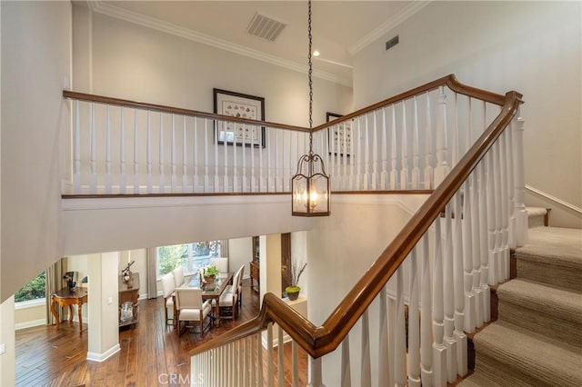 93 Old Course Dr, Newport Beach, CA 92660 - staircase with a chandelier, crown molding, hardwood / wood-style flooring, baseboards, and a towering ceiling