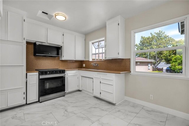 2607 Nearcliff St, Torrance, CA 90505 - kitchen with stainless steel microwave, electric range, light marble finish flooring, white cabinetry, and backsplash