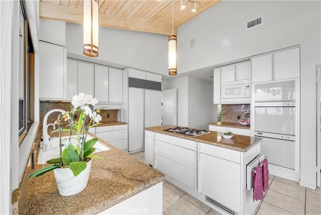 537 Dunnegan Pl, Laguna Beach, CA 92651 - kitchen featuring a high ceiling, a wood ceiling with exposed beams, paneled built in fridge, tasteful backsplash, and a center island