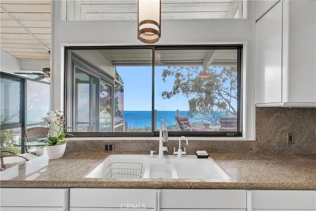 537 Dunnegan Pl, Laguna Beach, CA 92651 - kitchen with white cabinetry, backsplash, healthy amount of natural light, and stone countertops