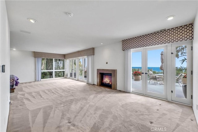 537 Dunnegan Pl, Laguna Beach, CA 92651 - unfurnished living room featuring carpet, a water view, a fireplace, recessed lighting, and french doors