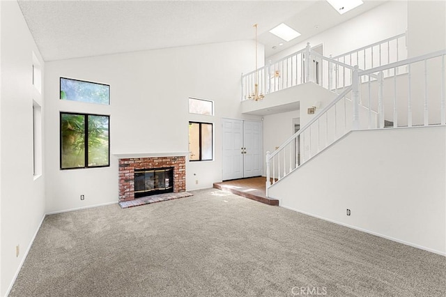 1234 Via Palermo, Redlands, CA 92374 - unfurnished living room with carpet flooring, high vaulted ceiling, stairway, baseboards, and a brick fireplace