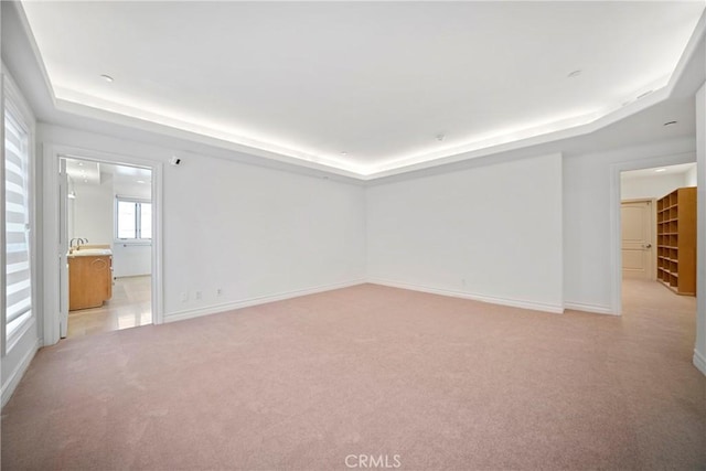 132 S Crescent Dr Unit 202, Beverly Hills, CA 90212 - empty room with a tray ceiling, light carpet, baseboards, and a sink