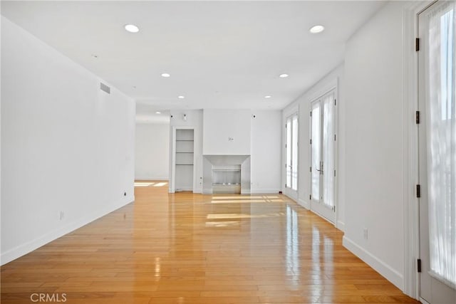 132 S Crescent Dr Unit 202, Beverly Hills, CA 90212 - unfurnished living room with built in shelves, light wood-style flooring, baseboards, and recessed lighting