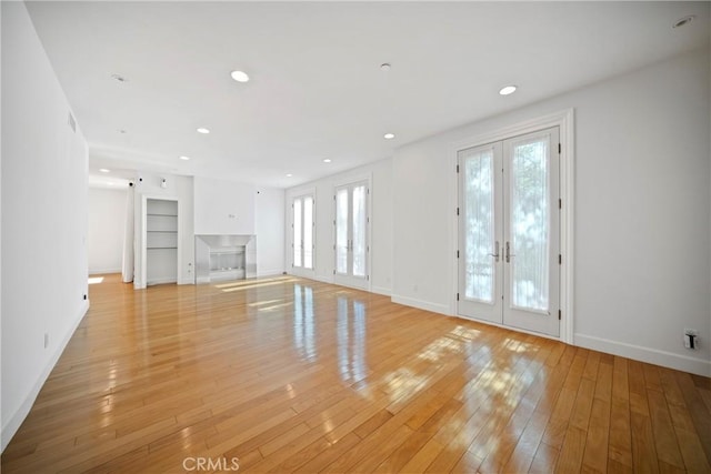 132 S Crescent Dr Unit 202, Beverly Hills, CA 90212 - unfurnished living room with french doors, baseboards, built in shelves, light wood-style flooring, and recessed lighting