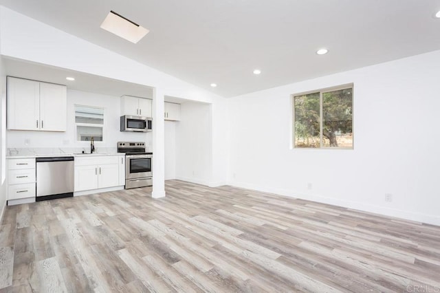 12049 Coping Pl, Lakeside, CA 92040 - kitchen featuring stainless steel appliances, lofted ceiling, light wood-style flooring, light countertops, and white cabinetry